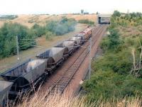 EWS 66051 leaving the north end of Millerhill yard with coal empties in the summer of 2000. The entrance to the former up reception sidings on the right is completely overgrown at this stage, while Newcraighall station and its associated turnback siding are not due to appear for another two years.<br><br>[John Furnevel 05/06/2000]