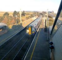 The 09.30 ex-Glasgow Central arrives at Prestwick Airport on 19 February 2013. View north through a window in the station footbridge.<br><br>[Colin Miller 19/02/2013]