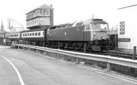 47467 brings a Glasgow Queen Street - Aberdeen train north over Camperdown level crossing in February 1982. The train has recently cleared Dock Street Tunnel shortly after leaving Dundee station. Camperdown Junction signal box towers over the scene, with the the Blue Circle cement terminal standing beyond and the spire of St Paul's Cathedral visible in the left background. The signal box finally closed in March 1985 and there is no longer a level crossing at this location.<br><br>[John Furnevel 04/02/1982]