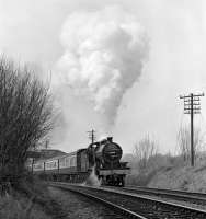Who would have thought in the early sixties, when the class was still in normal service on BR, that an ex-SDJR 2-8-0 would ever grace the metals of northern England? Preserved No. 13809 moves off from a stop at Wennington with the Carnforth to Hellifield leg of the 'Cumbrian Mountain Pullman' on March 27th 1982.<br><br>[Bill Jamieson 27/03/1982]