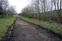 Ongoing work in February 2013 involving the upgrading of the cycle track which nowadays replaces the the siding that once ran from East Kilbride Station to Mavor and Couson's engineering works at Nerston. The line which was just under a mile in length closed in 1966. The boundary wall of East Kilbride Juniors football club is on the right, while garden walls of houses in the East Mains area of the town are on the left. [See image 19670]<br><br>[John Steven 22/02/2013]