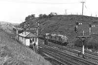 EE Type 3 No. 37098 trundles along the down slow line opposite Goose Hill Junction box, Normanton, with a train of empty spoil wagons on Saturday 12 February 1977. No doubt a positioning move in readiness for overnight track work come the cessation of normal traffic in the late evening. <br><br>[Bill Jamieson 12/02/1977]