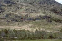 The morning train from Glasgow Queen Street hauled by 37410 approaches Glenfinnan station on 21 May 1987. Modern day travellers used to the luxury of class 156 units on this line will be grateful that they no longer have to put up with such primitive coaches as the one at the front of the train, a Mk 2d vehicle.<br><br>[Bill Jamieson 21/05/1987]