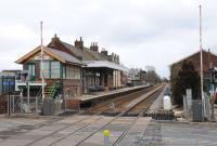 By December 2012 the Attleborough level crossing gates have been replaced by barriers. The semaphore signalling has been replaced by CLS. The signalman has been replaced by the shiny white Honeywell radar head on the right. The gates and signalling are described as radar - operated. The local community wishes to take over the signal cabin (1905) as a museum. For the first time in its history the station is unmanned. View towards Norwich in March 2013 [see image 36465].<br><br>[Brian Taylor 01/03/2013]