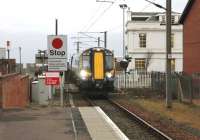 On a gloomy March afternoon, unit 380108 runs over Princes Street level crossing and into Ardrossan Town station with a service for Glasgow Central. The transformation, during the last six years, of the building on the far side of the crossing is a tremendous improvement. [See image 15067]<br><br>[Mark Bartlett 08/03/2013]