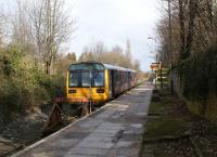 Looking north east from the buffers at Kirkby as 142031 waits to return to Manchester Victoria on 11 March 2013. This used to be a through route from Wigan Wallgate to Liverpool Exchange but today the line is split with the Merseyrail platform behind the photographer and Kirkby is now an end on - but unconnected - interchange.<br><br>[John McIntyre 11/03/2013]