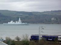 The type 45 destroyer Duncan (not HMS until commissioned) heads west down the Clyde en route from BAE Systems' Scotstoun Yard to Portsmouth Naval Base. Duncan is the last of six such vessels delivered. Passengers on a passing First ScotRail train were treated to an excellent view of the vessel and attendant tugboats along with Finlaystone Castle on the opposite bank.<br><br>[Beth Crawford 19/03/2013]