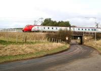 A morning Virgin Voyager from Edinburgh bound for Birmingham New Street crosses Lampits Road, Carstairs, on 8 March 2007. The train is approaching Carstairs East Junction where it will take the left fork to reach the WCML at Carstairs South (formerly Strawfrank) Junction [see image 11501].  <br><br>[John Furnevel 08/03/2007]