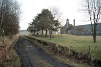 Remains of Knock station, Banffshire, looking north towards Tillynaught in 1997, some 29 years after closure of the line. The Knockdhu distillery stands on the right. Note the posts that once carried the station nameboard hiding amongst the trees. <br><br>[Ewan Crawford //1997]