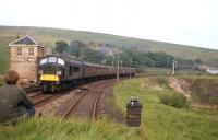 The photographer's son, during a camping holiday with his father at Riccarton Junction on a late spring afternoon in 1966, savours a Leeds 'Peak' battling up the 1 in 75 towards Whitrope Summit with the daily Carlisle-Edinburgh service conveying through coaches from St Pancras. Riccarton North box - a more attractive structure than its surviving sister at Riccarton South [see image 23830] - still survived despite having closed in April 1959. <br><br>[Frank Spaven Collection (Courtesy David Spaven) //1966]