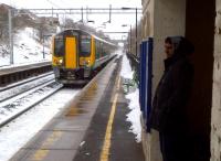 The gentleman on the right seems to be quite keen to be somewhere warmer, but the 14.35 to Birmingham New Street will only give him 6 minutes of defrosting time. A factory at the top of the cutting, just out of view to the right, was once the final assembly point for that great British institution, the half-timbered Morris Minor estate.<br><br>[Ken Strachan 24/03/2013]