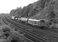 31175 approaches the west end of Horbury cutting in May 1977 on a short freight from Healey Mills Yard, the floodlights of which can be seen in the left background. Just beyond the rear of the train the chord to Crigglestone Junction diverges southwards off the ex-L&Y main line.<br><br>[Bill Jamieson 12/05/1977]