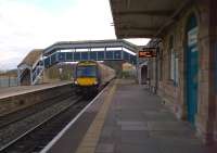 A CrossCountry Turbostar bound for Nottingham passes through Chepstow non-stop on 31st March 2013. The driver smiled as I juggled snack storage and photography. The former goods shed can be seen beyond the footbridge.<br><br>[Ken Strachan 31/03/2013]