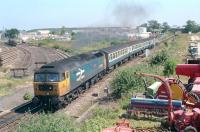 The eastern approaches to Elgin in 1990, with one of the class 47 hauled sets dredged up to handle the Sprinter withdrawal emergency arriving from Aberdeen en route to Inverness. The locomotive in charge is 47635 <I>Jimmy Milne</I>, currently preserved on the Peak Railway in Derbyshire.<br><br>[Ewan Crawford //1990]