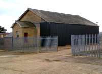 The goods shed at Rockingham station, near Caldecott village and North West of Corby, shows an interesting mixture of styles - restored original yellow brick; extension in red brick (left); and wholesale replacement by profiled steel (right). Unusually, both station and station master's house [see image 42674] also survive. View south west in April 2013.<br><br>[Ken Strachan 05/04/2013]