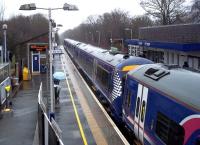 Raised umbrellas on platform 1 at Lenzie on 14 April as the 09.37 Glasgow Queen Street to Aberdeen Sunday morning service arrives in the rain.<br><br>[Andrew Wilson 14/04/2013]