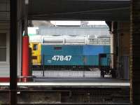 Riviera Trains large logo liveried blue 47847 is framed by platform 12 buildings as it stands on the west side of Crewe Station during coaching stock shunting activities in April 2013.<br><br>[David Pesterfield 16/04/2013]