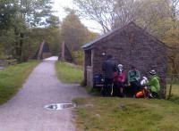 Well, at least the bar's open: a bunch of bedraggled walkers pausing for refreshment alongside the trackbed between Penrith and Keswick, oblivious to the bowstring girder bridge behind them. Notice the front wall of the PW hut, cut down to a 'counter' with a map inset into it.<br><br>[Ken Strachan 14/05/2012]