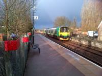 The 18.41 to Bletchley arriving at Lidlington, Bedfordshire, on 18 April 2013. The platform on the right has been rebuilt on the far side of the crossing, behind the photographer. There are quite a few new houses to the right of the train, making this perhaps the largest village between Bedford and Bletchley. The pillar box red floral containers on the left certainly brighten up the station.<br><br>[Ken Strachan 18/04/2013]