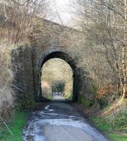 Approaching Penicuik from Auchendinny the line passed below this notable skew-arch bridge carrying a minor road. What looks like a level crossing gate in the distance is there to prevent unauthorised vehicles accessing the trackbed. Beyond the gate stood the small station of Eskbridge (closed in 1930) of which no trace remains [see image 22646].<br><br>[John Furnevel 20/04/2013]