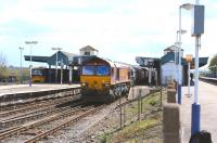 66074 brings a freight west through Didcot station on 26 April 2013, while over on the left a class 166 DMU is about to restart a service to Paddington.<br><br>[Peter Todd 26/04/2013]