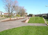 Approaching Bonnyrigg station from the south west on 30 April 2013. The platforms here have been landscaped and the trackbed now forms part of a walkway /cycleway. View is through the old station towards the site of the level crossing over the B704, beyond which stood the goods yard (now housing). Bonnyrigg closed to passengers in 1962, with the line from Hardengreen Junction closing completely in 1967.<br><br>[John Furnevel 30/04/2013]