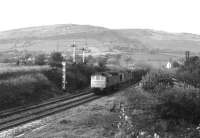 A pair of Class 25s taking the Peak Forest line at Chinley North Junction in the summer of 1979. Not surprisingly, the load is a long train of empty limestone hoppers. The Hope Valley line swings away to the right.<br><br>[Mark Bartlett //1979]