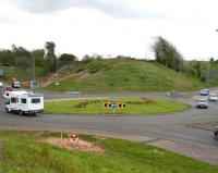 Looking south west over Hardengreen roundabout towards Newtongrange on 10 May 2013, with the A7 crossing the picture left to right. The new railway will span the roundabout at this point. An excavating machine can be seen at work on the embankment in the background. For the same view 3 years later [see image 54974].<br><br>[John Furnevel 10/05/2013]