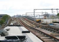 Looking east towards Edinburgh over the platforms of Balgreen tram stop on 12 May with a Virgin Voyager passing on the right slowing on the approach to Haymarket. Murrayfield Stadium is visible on the far left with Edinburgh Castle standing on the horizon. The tram stop is on the site of the former Balgreen Halt station on the old Corstorphine branch. The station closed to passengers in 1967 with the branch itself closing completely the following year.<br><br>[John Furnevel 12/05/2013]
