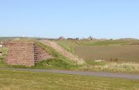 Remaining bridge abutment at Bullers O' Buchan on the Boddam Branch of GNSR in May 2013, with the embankment beyond curving away to the north towards Longhaven and Boddam. No trace remains of the old station, which closed to passengers as long ago as 1932.<br><br>[Brian Taylor 16/05/2013]