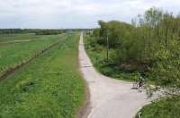 Looking south-east from the road bridge over the former CLC line from Southport to Liverpool at the site of Mossbridge station in May 2013. Nothing remains of the station which closed to passengers as long ago as January 1917, although the line itself survived until 1952. The trackbed is now used as the Cheshire Lines Path for cyclists and walkers.<br><br>[John McIntyre 19/05/2013]