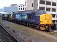 A more conventional view [see image 43153] of 37194 and 66511, laid over at Temple Meads on 19th May. The derelict building in the background is a former mail sorting office - notice the bridge from the platforms.<br><br>[Ken Strachan 19/05/2013]