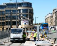 <i>'....AND YOU!'</i>  A construction worker on the Edinburgh Airport tram route exchanges greetings with the driver of a passing Airlink bus at Haymarket on 17 May.<br><br>[John Furnevel 17/05/2013]