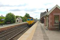 Coal empties destined for Scotland roll down the gradient through Langwathby station behind Freightliner 66561 in June 2013. The <I>Brief Encounter Tea Room</I> is still open in the main station building on the right, although presently (2013) up for sale.<br><br>[Mark Bartlett 05/06/2013]