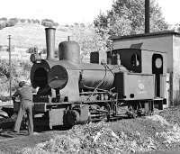 <I>Open wide, this won't hurt...</I> The Regua pilot, metre gauge 0-4-0T 049 001 having its tubes cleaned in the depot yard on Saturday 29th October 1983. Following withdrawal the locomotive was restored as E1 and placed on a plinth alongside the station [see image 43101].<br><br>[Bill Jamieson 29/10/1983]