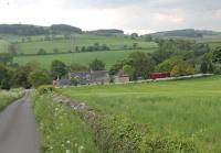 Wall station, the first on the Border Counties line out of Hexham, lies some way to the south of the small village it served. Since closure in 1956 it has become a private residence and has been extended. It is seen here from the A6079 road looking down towards the River North Tyne. There is a Mk1 BR coach at the north end of the station site.<br><br>[Mark Bartlett 06/06/2013]