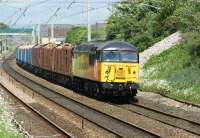 Colas Rail 56087 brings the Carlisle to Chirk log train through Hest Bank on 15 June 2013 in bright sunshine. Part of the closed Hest Bank level crossing box can just be seen left under the footbridge.<br><br>[John McIntyre 15/05/2013]