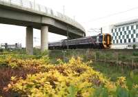 The 11.03 Edinburgh Waverley - Dunblane pulls away from Edinburgh Park station on 10 June. The train is passing below the tram flyover on which  track is ready to be laid.<br><br>[John Furnevel 10/06/2013]