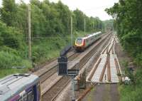 As a Wigan to Blackpool service runs beneath the camera on 23 June 2013 an up Voyager passes the prefabricated switch and crossing panels for the replacement of Balshaw Lane Jct during a 9 day possession in July.<br><br>[John McIntyre 23/06/2013]