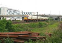 The 0957 Milngavie - Edinburgh Waverley approaching Edinburgh Park station on 10 June 2013. The train has just cleared the tram flyover and the A720 City Bypass beyond. <br><br>[John Furnevel 10/06/2013]