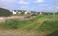 Looking north towards the site of Blairadam station on 6 June.  The curving field boundary marks the course of the railway, while the former goods yard is now occupied by industry and housing.  Just one of many obstructions to rebuilding the direct Edinburgh - Perth line. [See recent news item]<br><br>[Bill Roberton 06/06/2013]