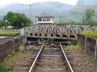 View over the Caledonian Canal from the adjacent foot crossing, looking towards Fort William over the closing Banavie swing bridge, with the RETB control centre seen beyond.<br><br>[David Pesterfield 25/06/2013]