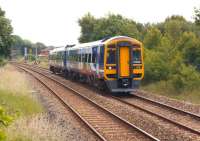 A York to Blackpool service slows as it approaches Lostock Hall station on 26 June 2013. In the background is Lostock Hall Junction with the electrified lines to Farington Junction coming in from the right.<br><br>[John McIntyre 26/06/2013]