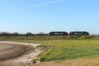 Having slowed to walking pace there is a tell tale plume from the exhausts of the two Class 37s as Arnside's home signal is cleared and the driver opens up the engines. The train is an evening DRS Sellafield to Crewe flask train.<br><br>[Mark Bartlett 19/06/2013]