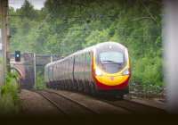 Viewed through the steps of a footbridge, a northbound Pendolino approaching Balshaw Lane Junction on 23 June 2013.<br><br>[John McIntyre 23/06/2013]