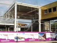 The atrium section of the new station building being erected at the north end of the up platform at Wakefield Westgate, complete with steps leading up to the recently installed DDA compliant footbridge running across to the down platform.<br><br>[David Pesterfield 09/07/2013]