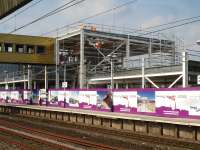 The south side of the atrium section of the new station building being erected at the north end of the up platform at Wakefield Westgate, with work taking place to complete the lift shaft to the recently installed footbridge to the down platform.<br><br>[David Pesterfield 09/07/2013]