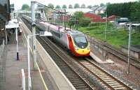 The 13.40 Glasgow Central - London Euston Pendolino runs through Lockerbie's platform 2 at speed on 11 June. <br><br>[John Furnevel 11/06/2013]