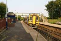 Not stopping at Rishton. A Northern 158 service from Blackpool to York hurries through Rishton station, shortly after leaving Blackburn on 5 July 2013. The next scheduled stop will be Accrington.<br><br>[John McIntyre 05/07/2013]