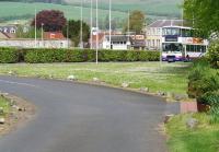 The NB approach to Peebles from Galashiels in 2010 looking north west from <I>The Bridges</I> [see image 31892] towards the A703. The line split here with the passenger route veering right towards the bus (the station lay beyond) and a line straight ahead into the goods yard (behind the hedge). The bus is on the NB/Caley link line which continued south to cross the Tweed and join up with the Caledonian. The old goods/weighbridge office survives in the background. <br><br>[John Furnevel 21/05/2010]